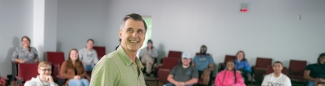 Man standing in front of a group of students in a lecture hall