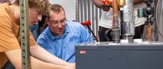 student and instructor working on an HVAC unit
